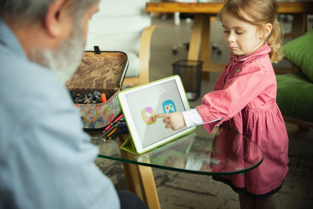 A young girl joyfully engages with an iPad, immersed in her playful activities.