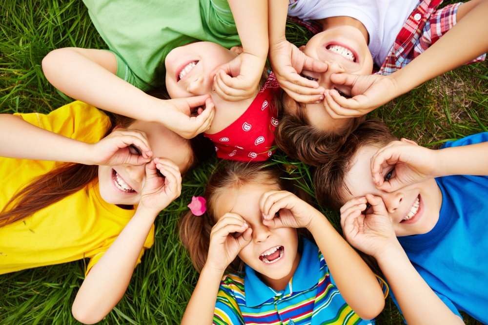 kid's in colorful dress laying on grass land.