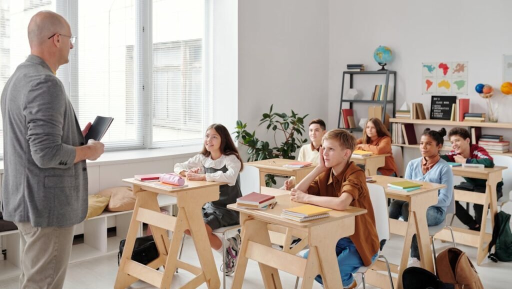 In the classroom, the teacher is teaching, and the students are listening attentively.