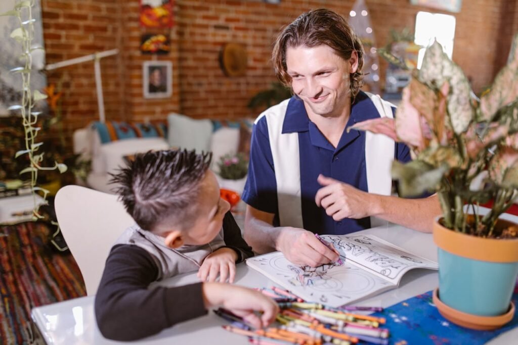 Modeling Positive Behaviors- A father and his son are coloring a book together.