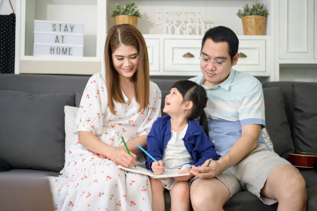 Happy parent teaching little cute daughter to do homework and drawing picture together at home.
best teacher training institute Borivali, Mumbai.